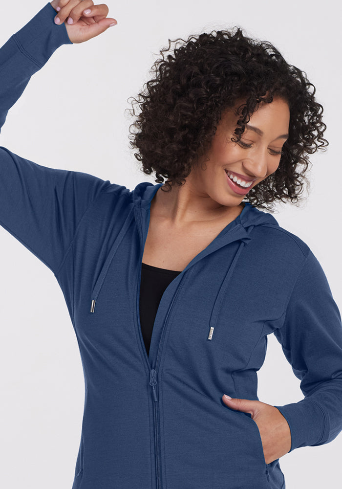 Woman smiles with eyes closed in the Woolx Ryann Hoodie • Final Sale - Starry Night, one arm raised, other on hip.