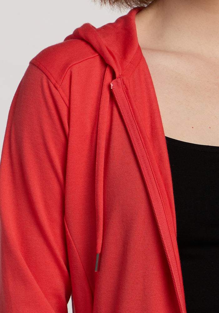 Close-up of a person in the Woolx Ryann Hoodie - Hibiscus over a black top, showing shoulder and chest.