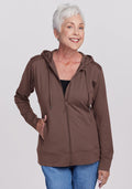 Smiling older woman in a Woolx Ryann Hoodie - Peppercorn and blue jeans, standing with one hand in her pocket. | Kathy is 5’9”, wearing a size S