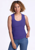 Woman with curly hair wearing the Woolx Sloane Ribbed Tank in Berry Indigo and blue jeans, smiling at the camera. | Tori is 5'7", wearing a size S