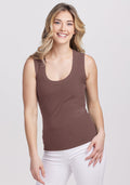 Smiling woman in Woolx Sloane Ribbed Tank - Peppercorn, white pants, wavy blonde hair, against a light background. | Ariana is 5'11", wearing a size S