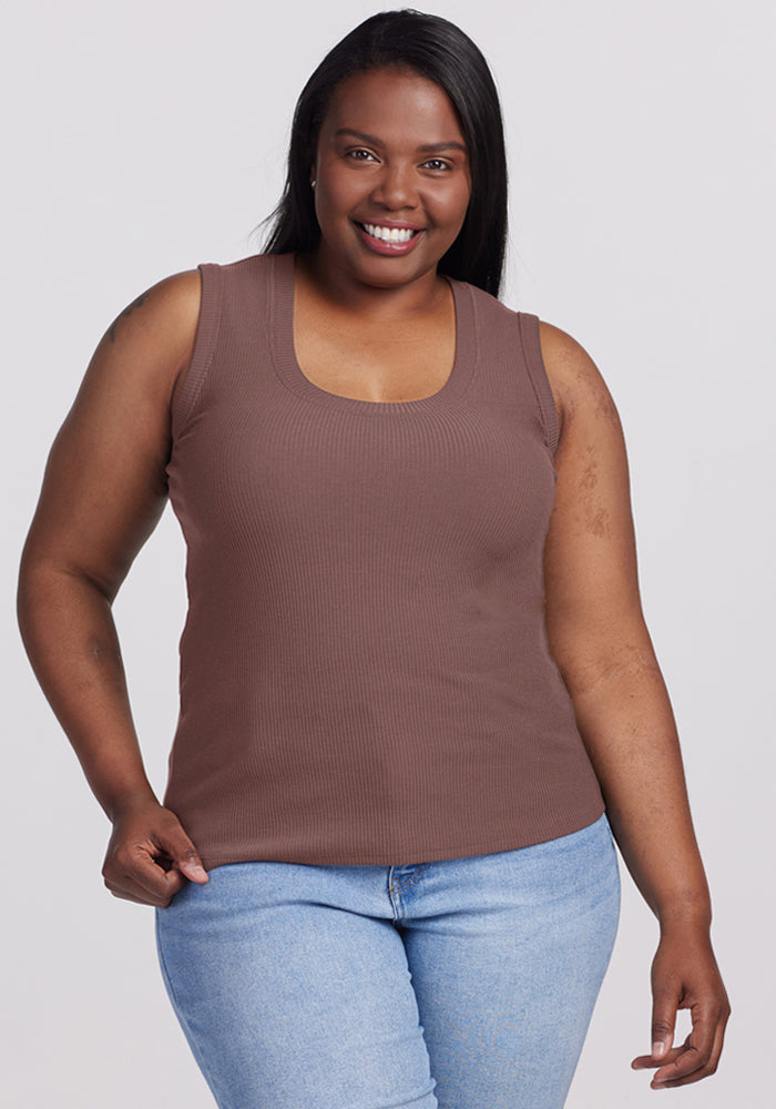 Smiling woman in a Woolx Sloane Ribbed Tank - Peppercorn and light blue jeans poses against a plain background. | Le'Quita is 5'11", wearing a size XL
