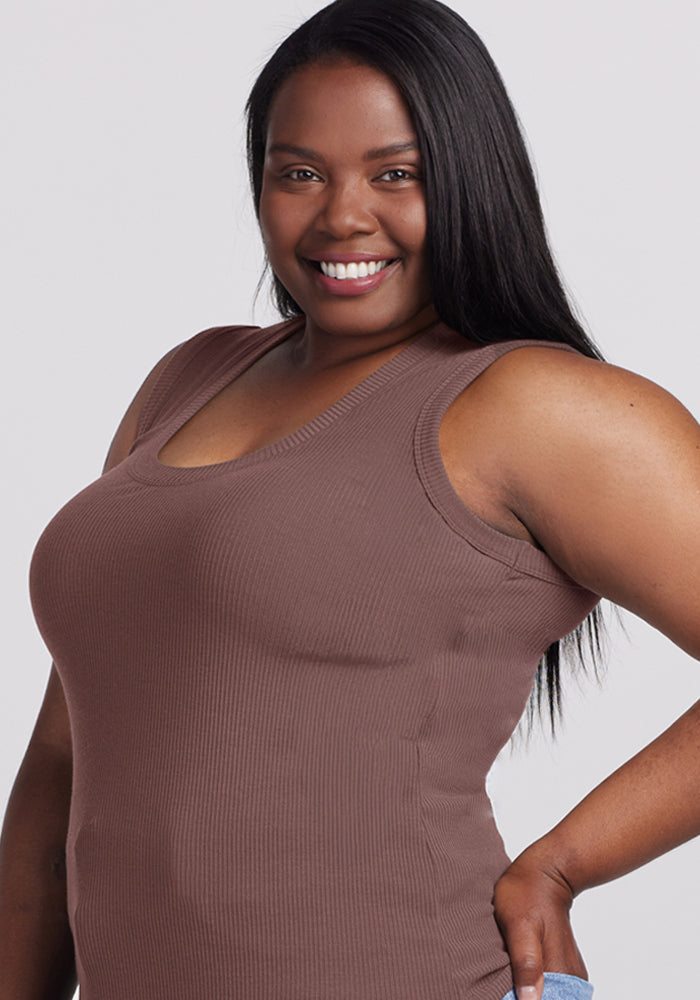 Confident woman poses in the Woolx Sloane Ribbed Tank in Peppercorn, hand on hip against a plain background.