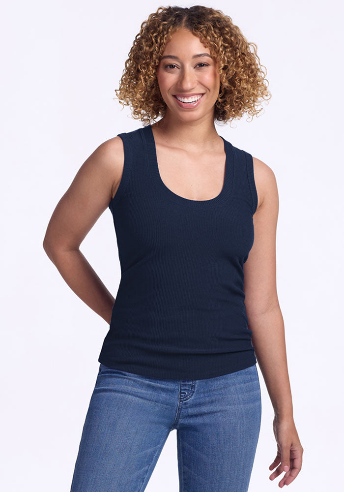Smiling woman in Woolx Sloane Ribbed Tank, Deep Navy (Final Sale) and blue jeans against a plain white background.