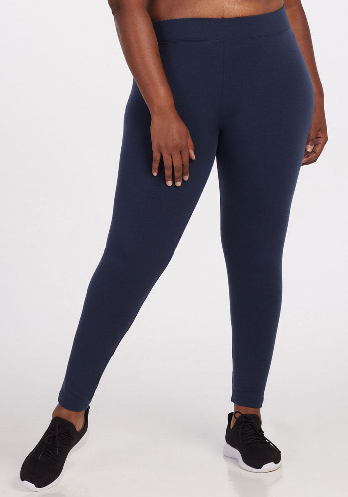 A person models the Woolx Stella Tall leggings in Deep Navy (Final Sale Deals!), paired with black sneakers, against a white background. Only the lower half of their body is shown.