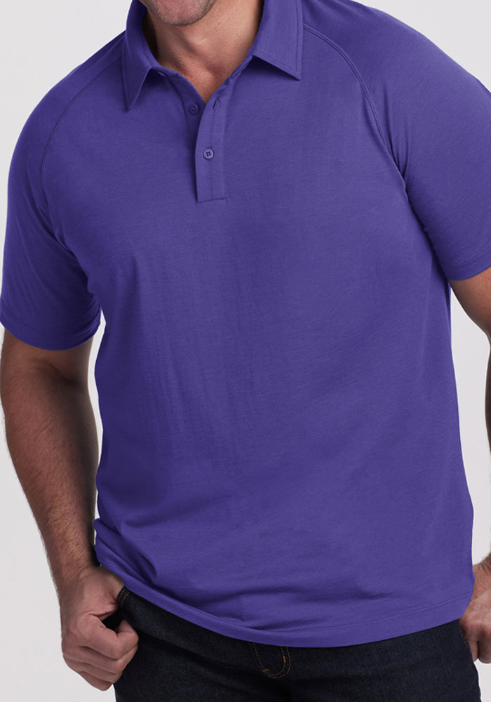 Man in Woolx Summit Polo - Berry Indigo and dark jeans, standing against a light background.