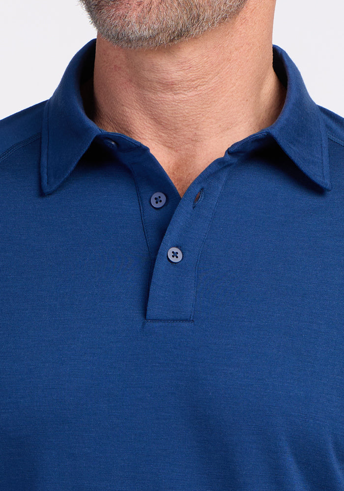 Close-up of a man in the Woolx Summit Polo • Final Sale - Estate Blue, two buttons fastened, for comfort and moisture control.
