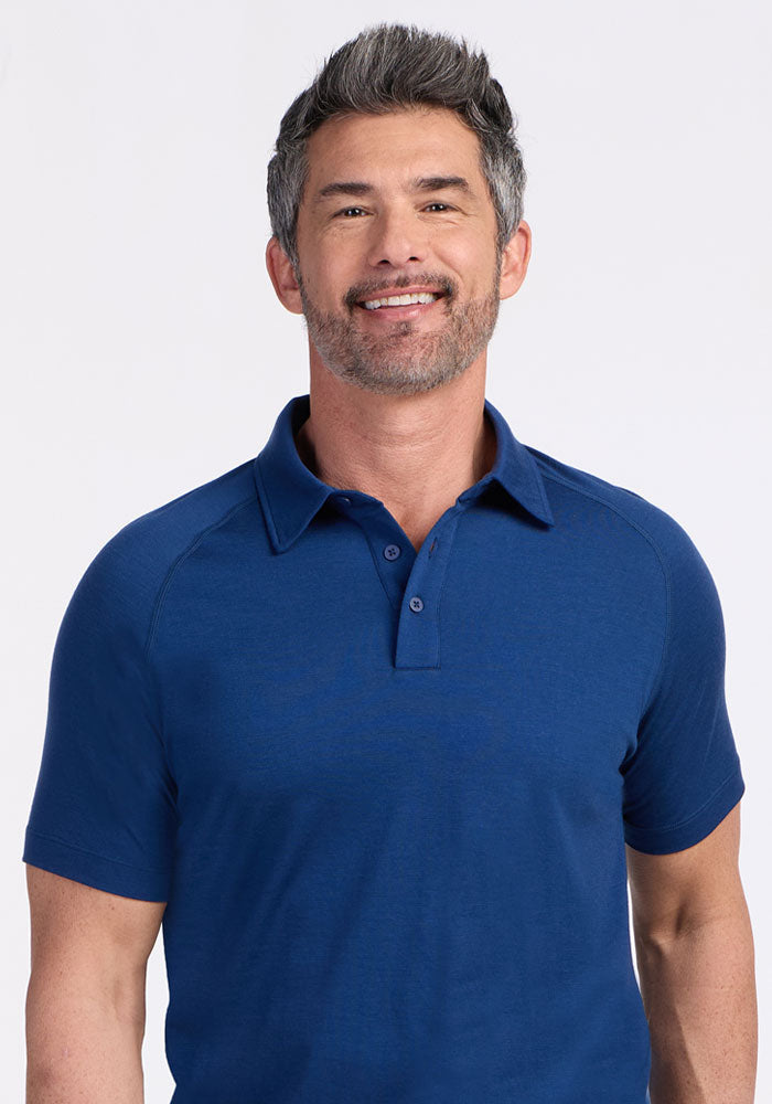Smiling man in Woolx Summit Polo • Final Sale - Estate Blue, standing against a plain light background.