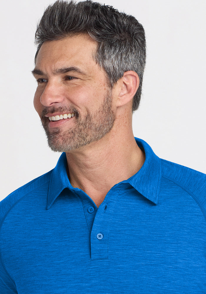 Smiling man in the Woolx Summit Polo in Glacial Blue, with short gray hair and a beard, looking to the side.