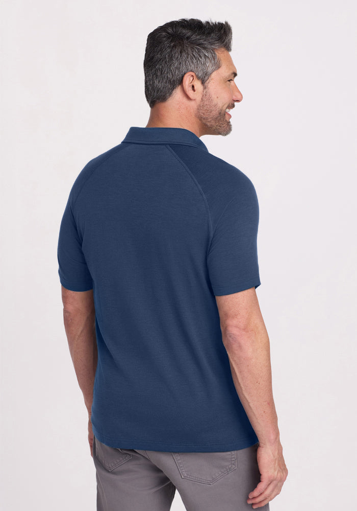 Man with short dark hair in a Woolx Summit Polo • Final Sale - Starry Night and gray pants, facing away from camera.