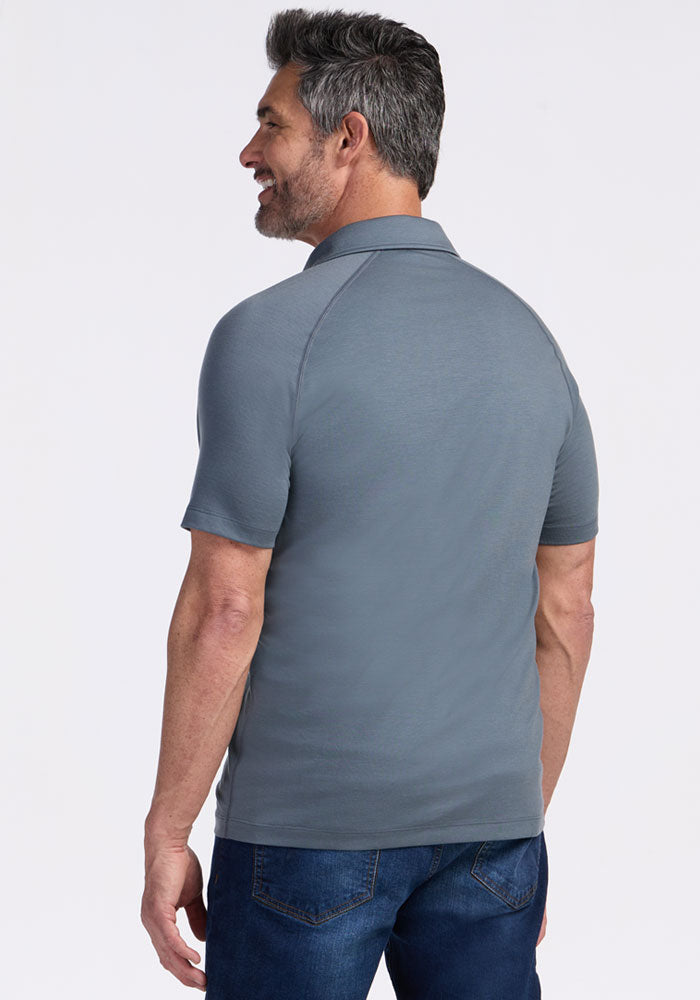 A man with gray hair wears the Woolx Summit Polo • Final Sale - Stormy Weather and blue jeans, facing away from camera.