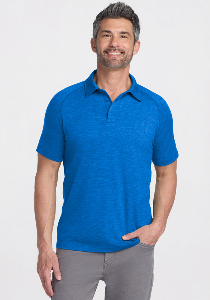 Smiling man in the Woolx Summit Polo • Final Sale - Glacial Blue and gray pants, showcasing high-performance gear.
