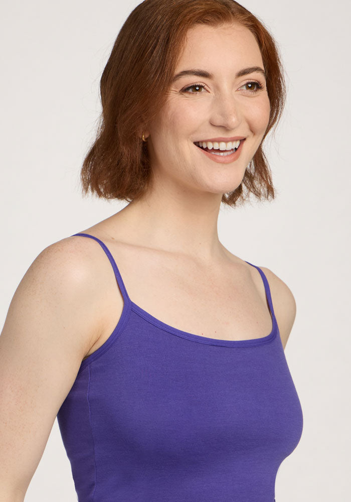 Smiling woman with short auburn hair in the Woolx Teagen Cami With Shelf Bra in Berry Indigo, facing right.