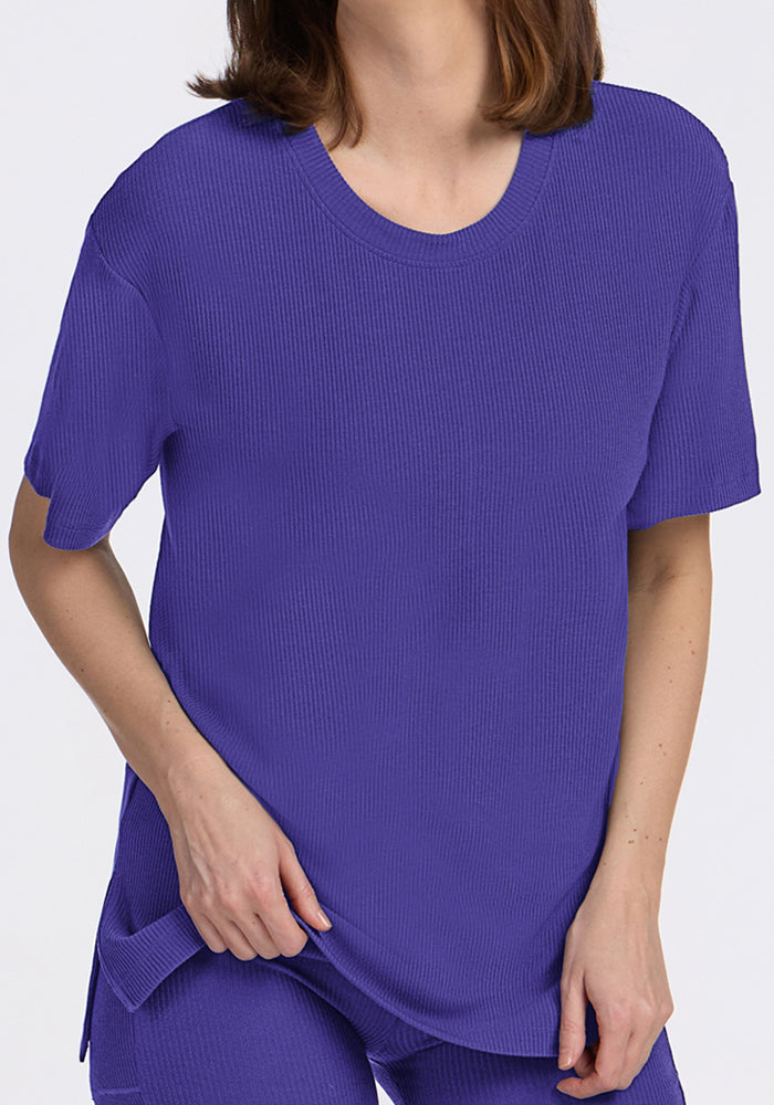 Woman in the Woolx Vera Ribbed Tunic in Berry Indigo, paired with matching pants, against a plain background.