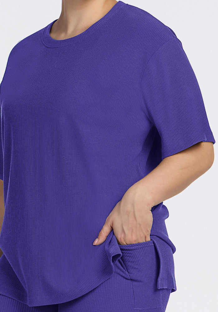 A person in a relaxed fit Woolx Vera Ribbed Tunic - Berry Indigo with one hand in their matching pants pocket.