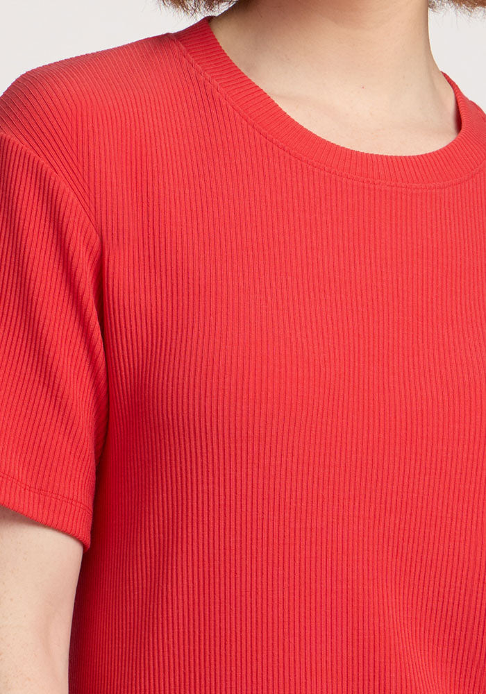 Close-up of a person wearing the Woolx Vera Ribbed Tunic in Hibiscus, showing the neckline and upper chest.