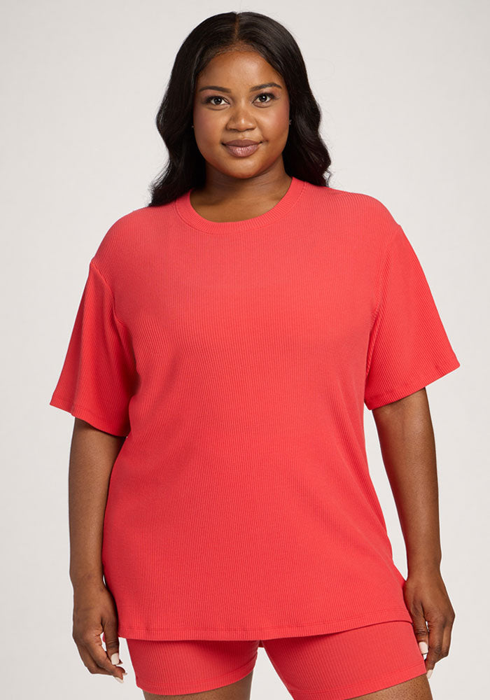 Woman in the Woolx Vera Ribbed Tunic - Hibiscus and matching shorts, standing against a plain background. | Sapphire is 5’8”, wearing a size XL