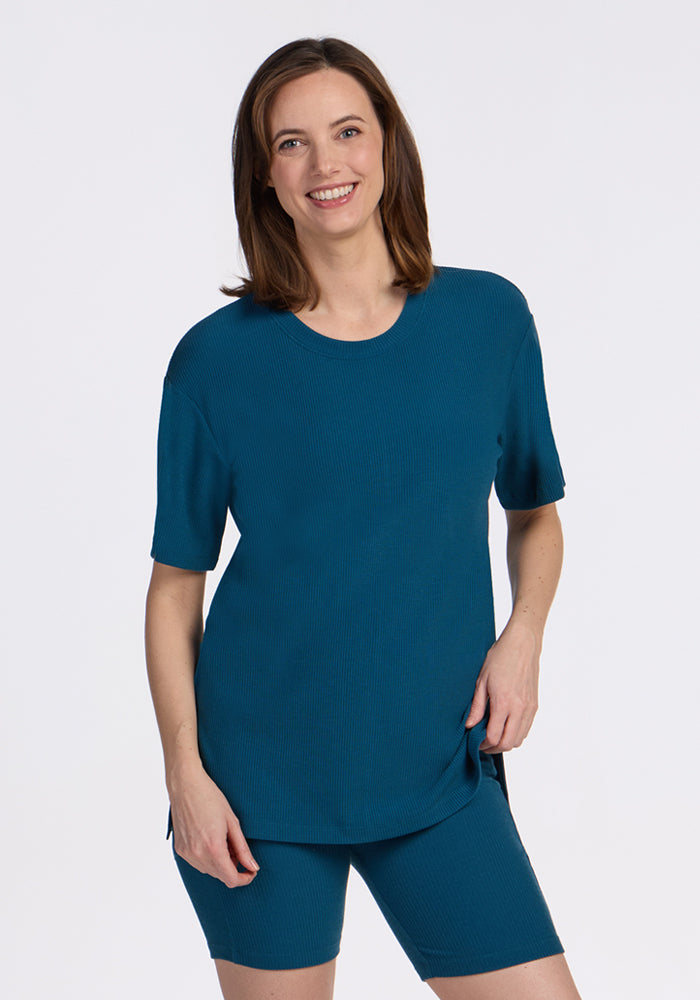 Woman smiling in the Woolx Vera Ribbed Tunic in Moroccan Blue, relaxed fit, posing against a plain white background.