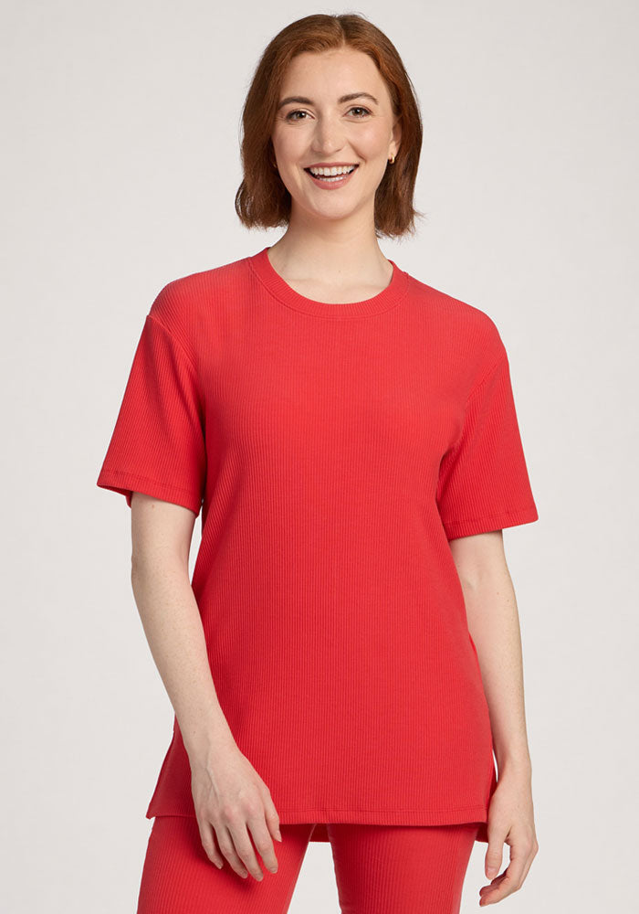A woman with short brown hair smiles in the Woolx Vera Ribbed Tunic in Hibiscus, relaxed fit and stylish. | Shea is 5’9”, wearing a size S