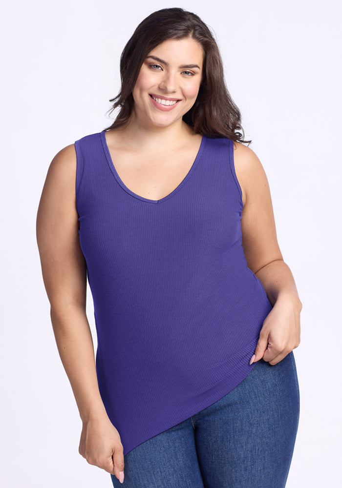 Smiling woman in a Woolx Vivi Ribbed Tank - Berry Indigo and blue jeans against a light background. | Juliana is 5'10", wearing a size XL