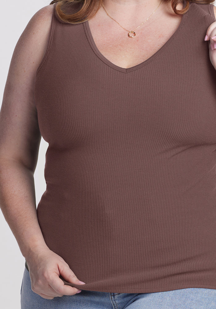 A woman in a Woolx Vivi Ribbed Tank in Peppercorn and light blue jeans, shown from shoulders to hips.
