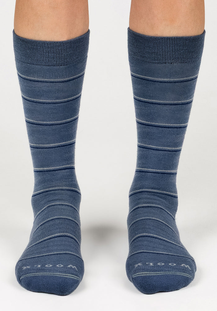 A pair of feet wearing Woolx Womens Chandler Mid Calf Socks in Vintage Indigo with thin horizontal white stripes, shown from the front against a plain white background.