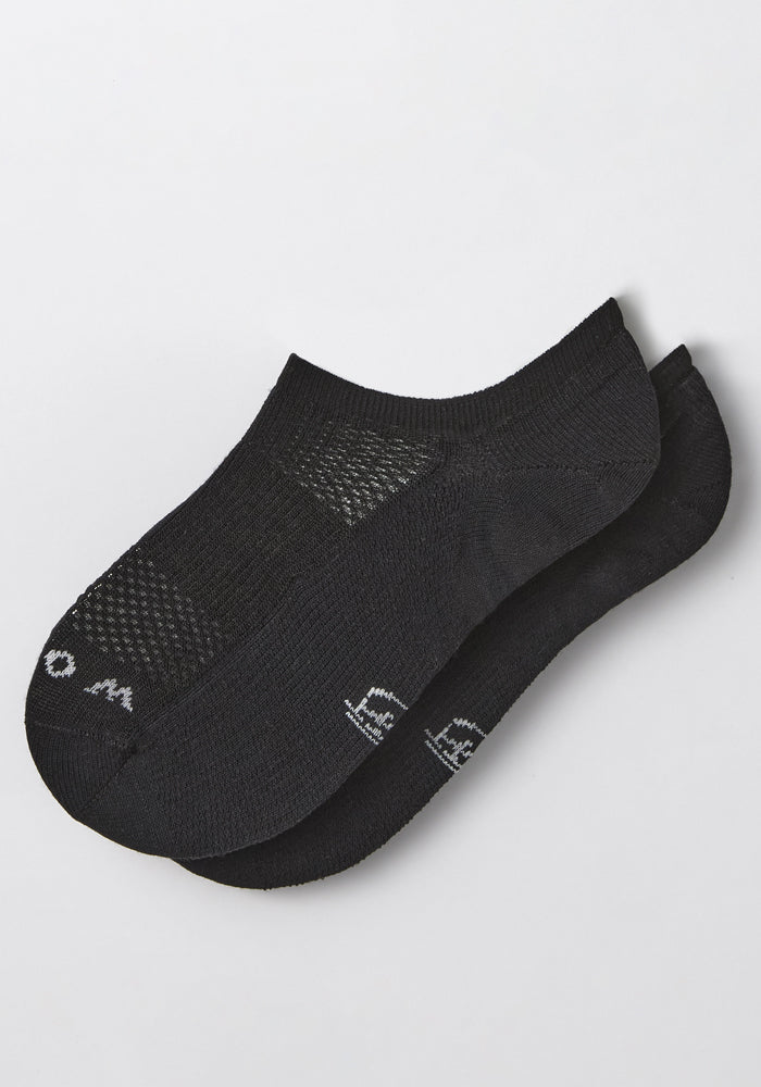 A pair of Woolx Womens Daisy Ped Socks in Black Pepper with mesh ventilation on top and small white text near the toes, shown on a plain white background.