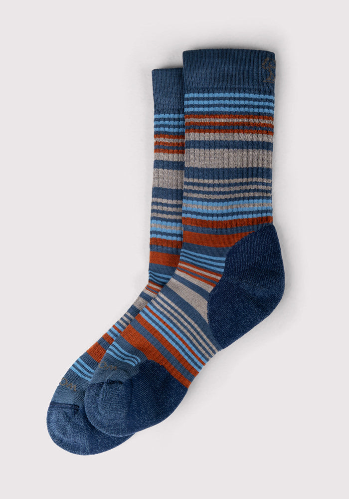 Woolx Womens Everyday Crew Socks in Majolica Blue Stripe feature cushioned comfort, multicolored horizontal stripes, and solid dark blue heels, toes, and cuffs, displayed on a light background.