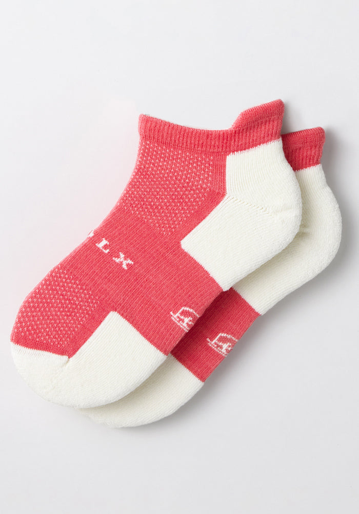 The Woolx Womens Rowan No Show Socks - Taffy Twist feature a pink body with white heel, toe, and cuff accents, arranged overlapping on a plain white background.