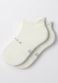The Woolx Womens Rowan No Show Socks in White Lightning feature cushioned ankle support and subtle gray sole lettering, shown overlapping on a plain white background.