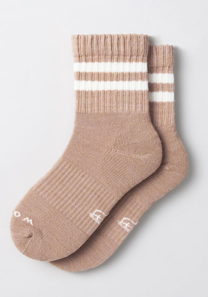 The Womens Varsity Mini Crew Socks - Morning Latte by Woolx are brown athletic crew socks featuring two white stripes near the top and small white embroidered letters on the toes, displayed flat on a light background.