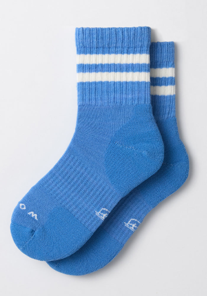 Woolx Womens Varsity Mini Crew Socks - Wave Rider: blue athletic crew socks with two white stripes near the top, ribbed cuffs, and white text by the toes. Overlapping on a white background, these socks are designed for comfort and performance.